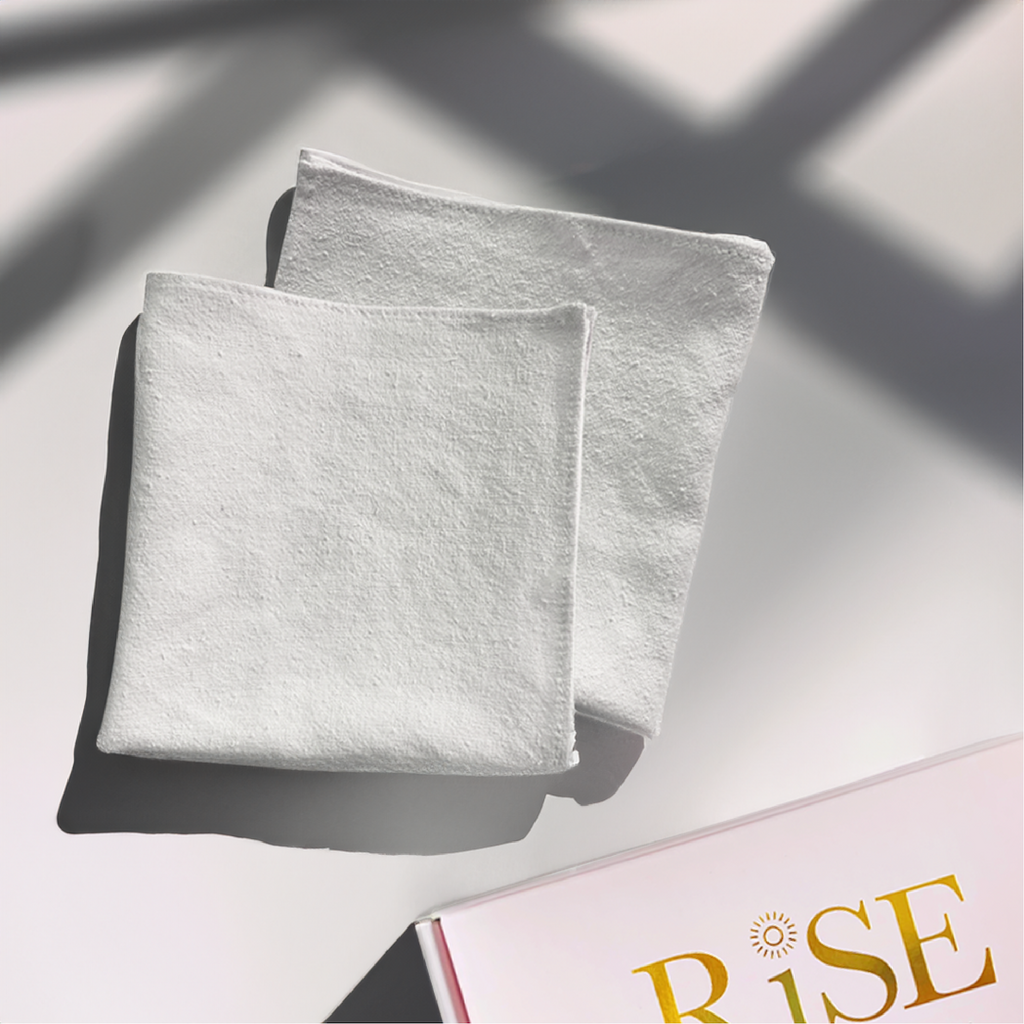 Two silk washcloths and RISE pink box packaging in corner