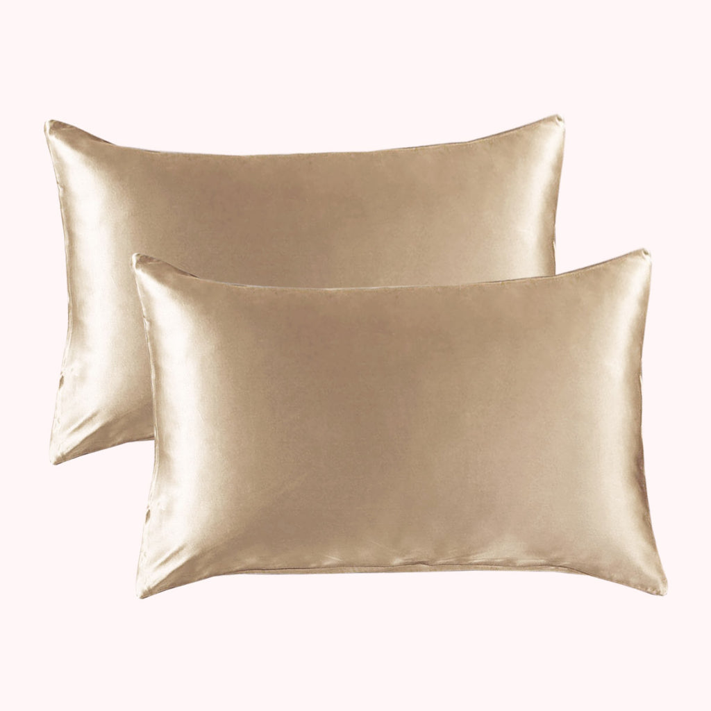 2 pillows encased in light gold satin pillowcases