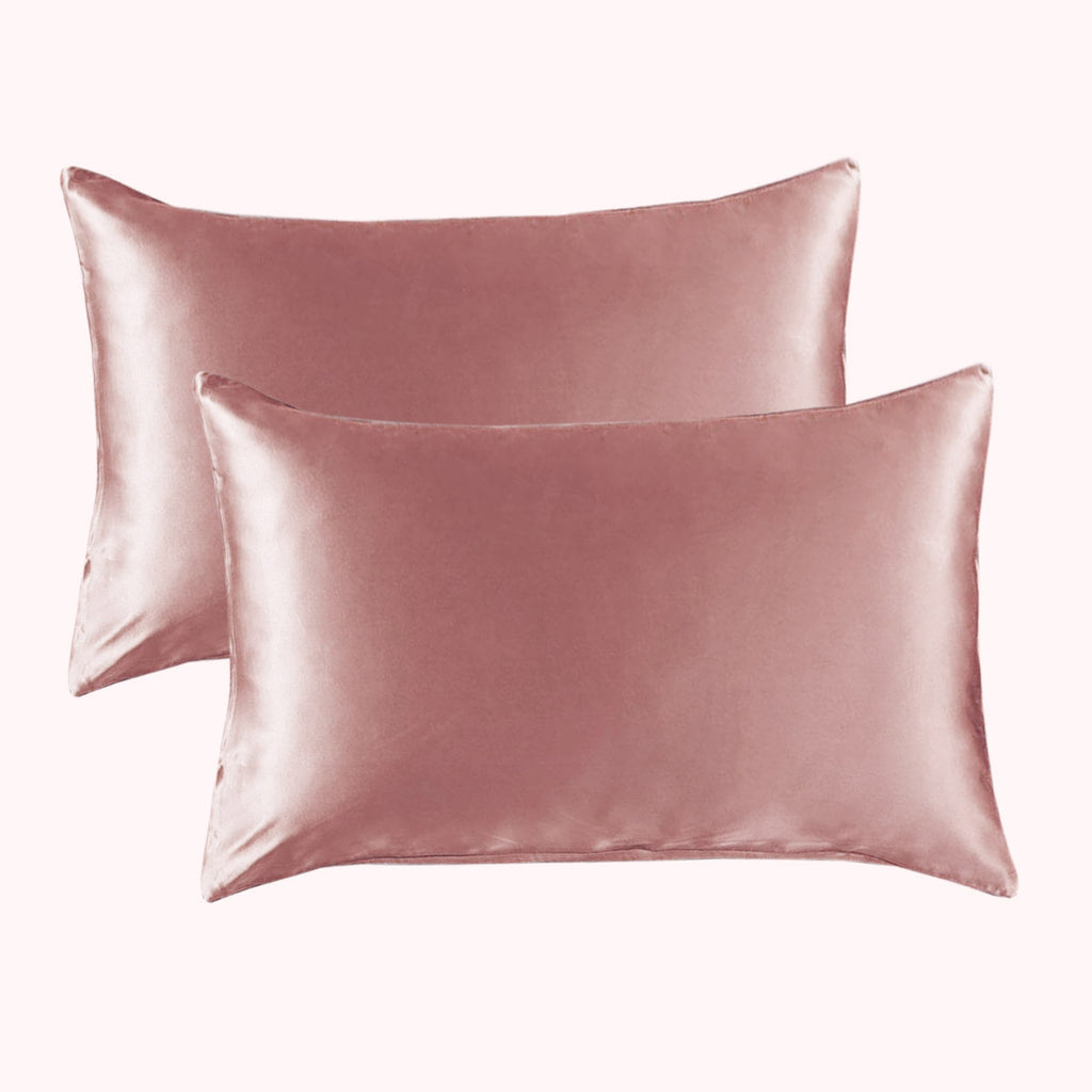 2 pillows encased in light pink satin pillowcases