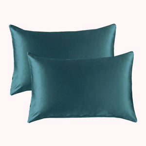 2 pillows encased in teal satin pillowcases
